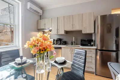 a kitchen with a glass table and a stainless steel refrigerator at 3BDR Penthouse, Rooftop and BBQ in Crescent in Montréal