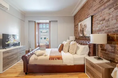 a bedroom with a bed and a brick wall at 3BDR Penthouse, Rooftop and BBQ in Crescent in Montréal