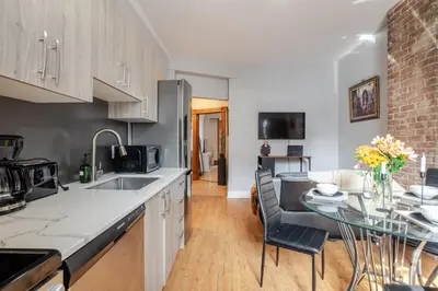 a kitchen with a sink and a table with chairs at 3BDR Penthouse, Rooftop and BBQ in Crescent in Montréal