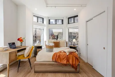 a bedroom with a bed and a desk and windows at Urban Studio on Bishop Hot Spot Dtown MTL in Montréal