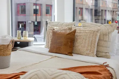 a bed with many pillows on it with a window at Urban Studio on Bishop Hot Spot Dtown MTL in Montréal