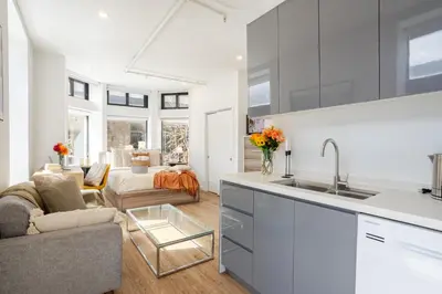 a kitchen with a sink and a living room at Urban Studio on Bishop Hot Spot Dtown MTL in Montréal