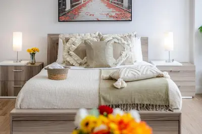 a bedroom with a bed and two lamps and flowers at Lovely Loft with Views on Bishop - MTL in Montréal