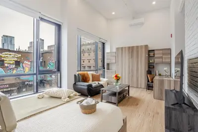 a living room with a couch and a large window at Lovely Loft with Views on Bishop - MTL in Montréal