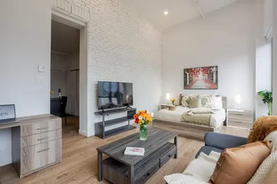 a living room with a couch and a tv at Lovely Loft with Views on Bishop - MTL in Montréal
