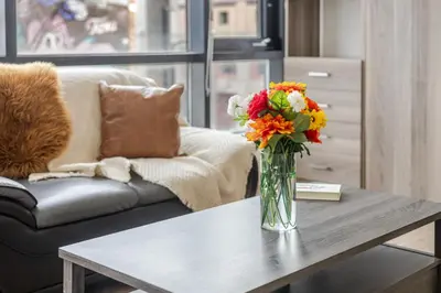 a vase of flowers on a table in a living room at Lovely Loft with Views on Bishop - MTL in Montréal