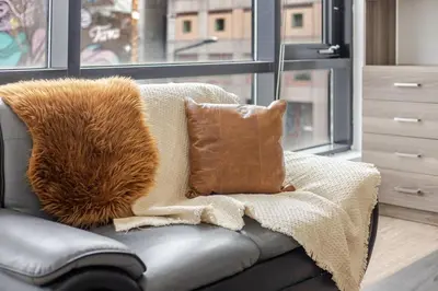 a couch with a blanket and a pillow on it at Lovely Loft with Views on Bishop - MTL in Montréal