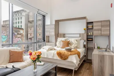 a bedroom with a large bed with a large window at Lovely Loft with Views on Bishop - MTL in Montréal