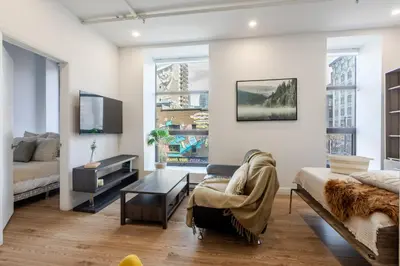 a bedroom with a bed and a living room at Modern 1BDR Apartment on Bishop - MTL in Montréal