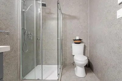 a bathroom with a toilet and a glass shower at Modern 1BDR Apartment on Bishop - MTL in Montréal