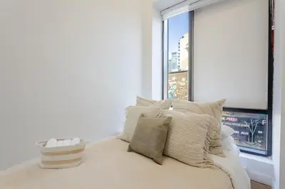a bedroom with a bed with pillows and a window at Modern 1BDR Apartment on Bishop - MTL in Montréal