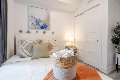 a bedroom with a white bed with a basket at Urban 1BDR Apartment on Bishop -MTL Live Spot in Montréal