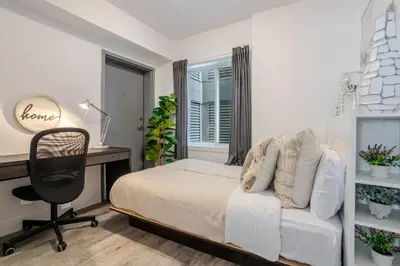 a bedroom with a bed and a desk and a chair at Urban 1BDR Apartment on Bishop -MTL Live Spot in Montréal