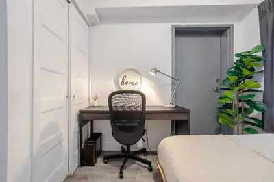 a bedroom with a desk with a chair next to a bed at Urban 1BDR Apartment on Bishop -MTL Live Spot in Montréal