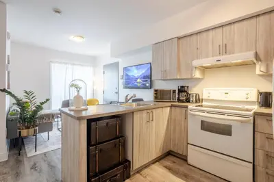 a kitchen with wooden cabinets and a counter top at Urban 1BDR Apartment on Bishop -MTL Live Spot in Montréal