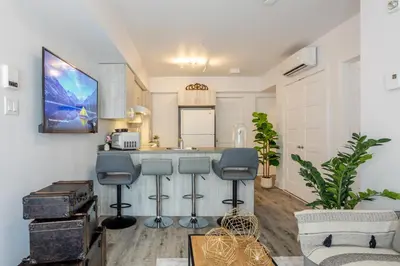 a kitchen with a counter and stools in a room at Urban 1BDR Apartment on Bishop -MTL Live Spot in Montréal