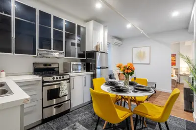 a kitchen with a table and yellow chairs at Charming 1BDR Apartment on Bishop St- MTL in Montréal