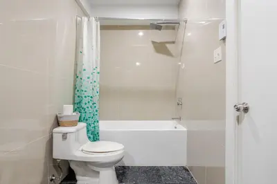 a white bathroom with a toilet and a shower at Charming 1BDR Apartment on Bishop St- MTL in Montréal