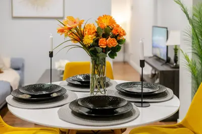 a table with plates and a vase of flowers on it at Charming 1BDR Apartment on Bishop St- MTL in Montréal