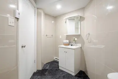 a white bathroom with a sink and a mirror at Charming 1BDR Apartment on Bishop St- MTL in Montréal