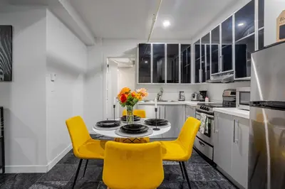 a kitchen with a table and yellow chairs at Charming 1BDR Apartment on Bishop St- MTL in Montréal