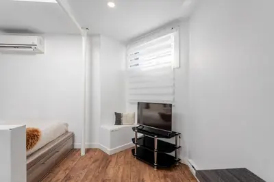 a living room with a tv and a window at 1BDR Mezzanine-Bishop-Vibe Central MTL in Montréal