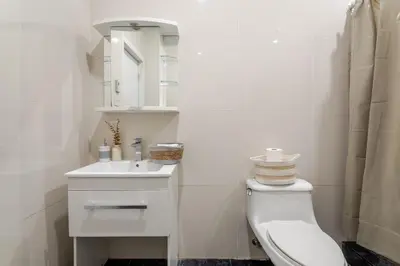 a white bathroom with a toilet and a sink at 1BDR Mezzanine-Bishop-Vibe Central MTL in Montréal