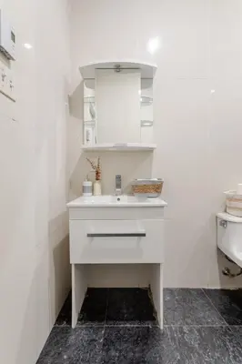 a white bathroom with a sink and a mirror at 1BDR Mezzanine-Bishop-Vibe Central MTL in Montréal