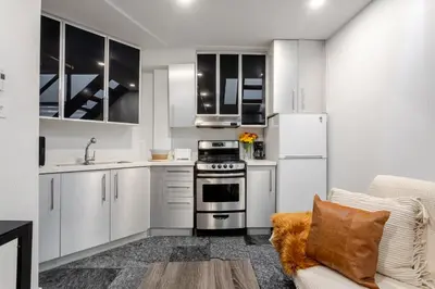 a kitchen with white cabinets and a stove at 1BDR Mezzanine-Bishop-Vibe Central MTL in Montréal