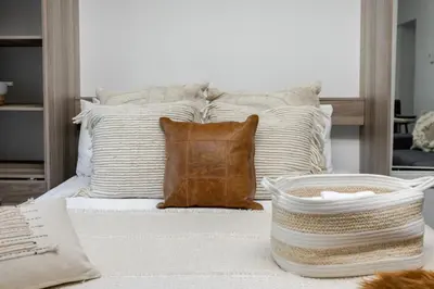 a bed with pillows and a basket on top of it at Spacious 1BDR Mezzanine on Bishop Central MTL in Montréal