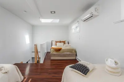 a white room with two beds in it at Spacious 1BDR Mezzanine on Bishop Central MTL in Montréal
