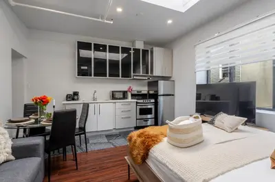 a kitchen and living room with a bed and a table at Spacious 1BDR Mezzanine on Bishop Central MTL in Montréal