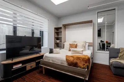 a bedroom with a large flat screen tv and a bed at Spacious 1BDR Mezzanine on Bishop Central MTL in Montréal