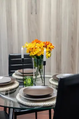 a table with plates and a vase of flowers on it at Spacious 1BDR Mezzanine on Bishop Central MTL in Montréal