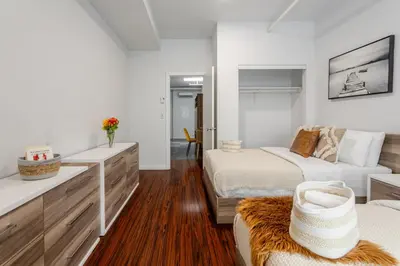 a white bedroom with two beds and a couch at Central 1BDR Apartment on Bishop Central MTL in Montréal