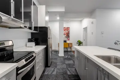 a kitchen with white counters and a black refrigerator at Central 1BDR Apartment on Bishop Central MTL in Montréal