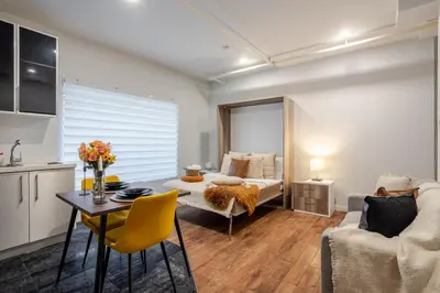 a living room with a bed and a table at Spacious Studio on Bishop - Hot Spot Dtown MTL in Montréal