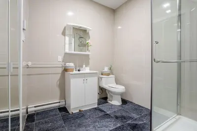 a white bathroom with a toilet and a shower at Spacious Studio on Bishop - Hot Spot Dtown MTL in Montréal