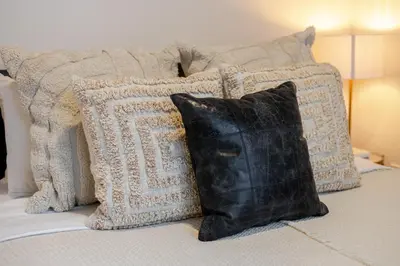 a black pillow sitting on a bed with four pillows at Stylish 1BDR Apartment in the Heart of DT MTL in Montréal