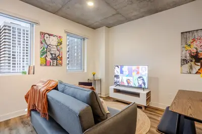 a living room with a blue couch and a tv at Stylish 1BDR Apartment in the Heart of DT MTL in Montréal