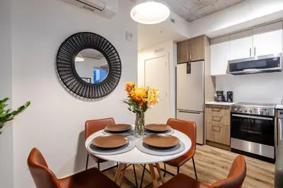 a kitchen and dining room with a table and chairs at Cute 1BDR Apt in Ste-Catherine - MTL Live Spot in Montréal