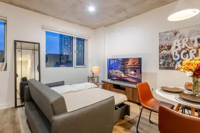 a room with a bed and a table and a tv at Cute 1BDR Apt in Ste-Catherine - MTL Live Spot in Montréal
