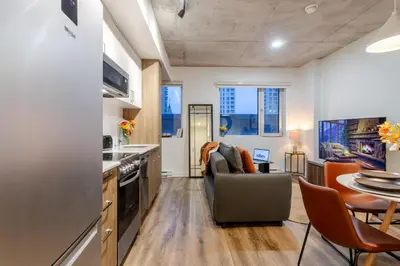 a kitchen and living room with a couch and a table at Cute 1BDR Apt in Ste-Catherine - MTL Live Spot in Montréal