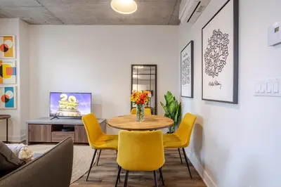 a living room with a table and yellow chairs at Modern 1BR in downtown in Montréal