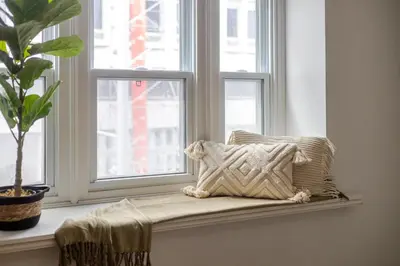 a pillow sitting on a window sill next to a plant at Central 2BDR Condo on Bishop-Vibe Central MTL in Montréal