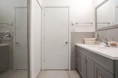 a bathroom with a shower and a sink and a mirror at Central 2BDR Condo on Bishop-Vibe Central MTL in Montréal