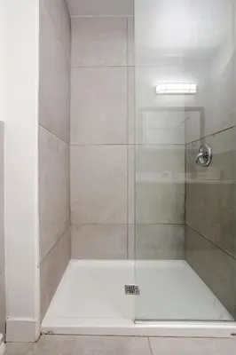 a shower with a glass door in a bathroom at Central 2BDR Condo on Bishop-Vibe Central MTL in Montréal