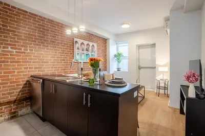 a kitchen with a sink and a brick wall at Central 2BDR Condo on Bishop-Vibe Central MTL in Montréal