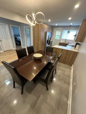 a dining room with a table and chairs and a kitchen at Luxieux Appartement laval in Laval
