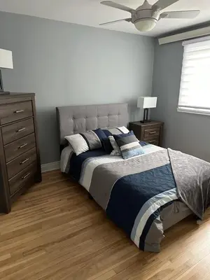 a bedroom with a large bed and a dresser at Luxieux Appartement laval in Laval